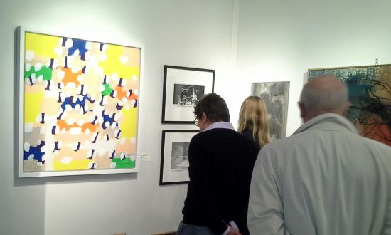 Élysées Art Fait visitors at Galerie Chauvy stand looking atsome Marcel Barbeau's art works.